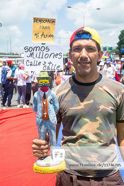 A man holds an image of Jose Gregorio Hernandez in the march we are millions. Venezuelans opposed to the government gathered on Saturday  May 20  2017  on the Francisco Fajardo motorway  in an activity called 'Somos Millones'  with which they intend to give the 'greatest demonstration of strength' they have given in almost two months of protests.