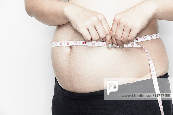Measuring tape around pregnant woman's bump