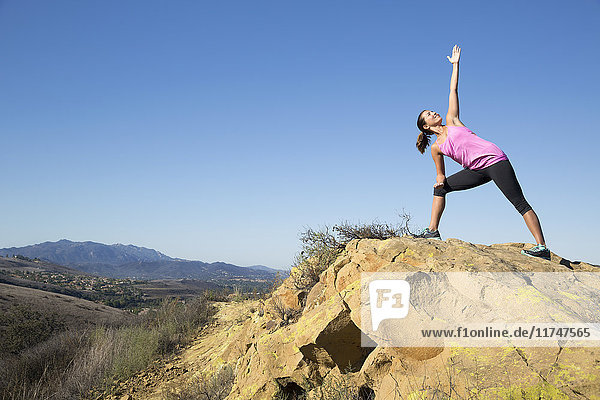 Frau  die auf einem Hügel eine Yogastellung einnimmt  Thousand Oaks  Kalifornien  USA