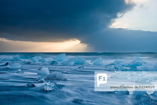Eisberge am Strand bei stürmischem Himmel Jokulsarlon Island