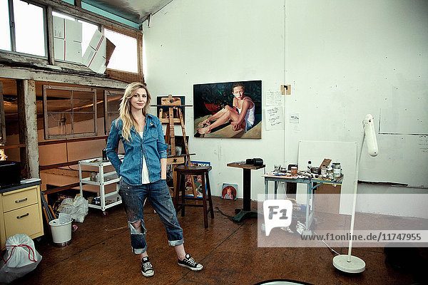 Mittlere erwachsene Frau im Atelier des Künstlers stehend  Porträt