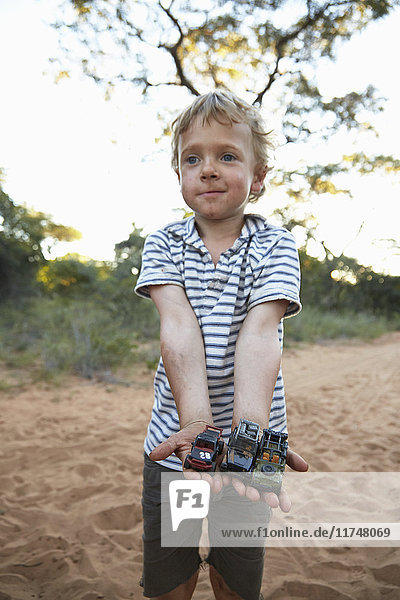 Porträt eines Jungen  der Spielzeugautos hält  Grootfontein  Kavango  Namibia