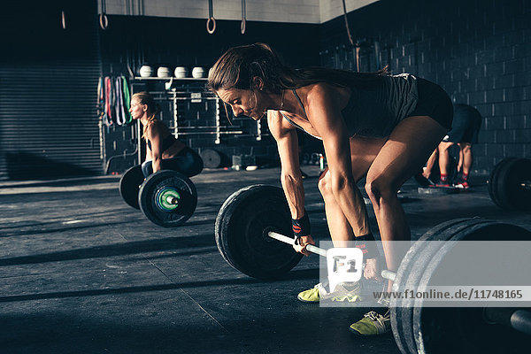 Women training with barbells in gym