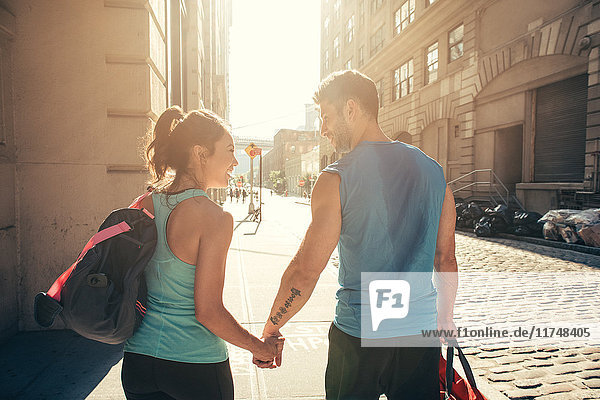 Young couple on street returning from training