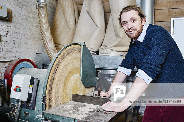 Porträt eines jungen männlichen Druckers mit einer Kreissäge in einer traditionellen Druckwerkstatt