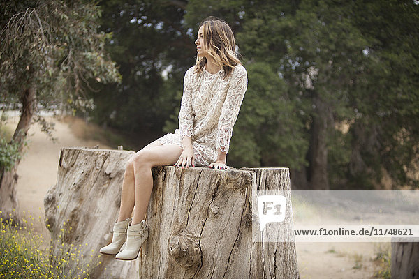 Frau sitzt auf einem Baumstamm im Park  Stoney Point  Topanga Canyon  Chatsworth  Los Angeles  Kalifornien  USA