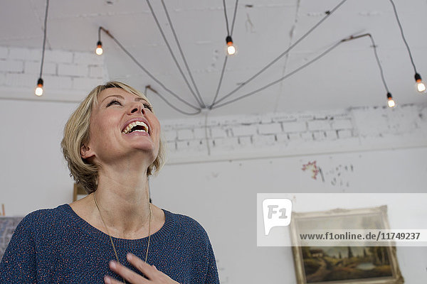 Mid adult woman laughing with head back