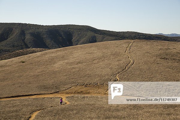 Distant view of female runner running through landscape  Thousand Oaks  California  USA