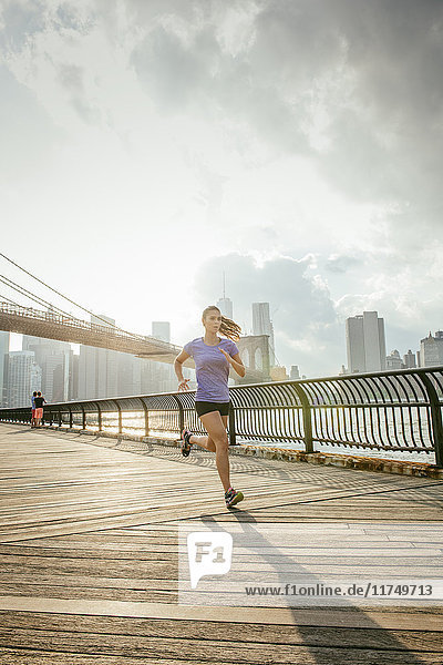 Junge Läuferin läuft am Flussufer  Brooklyn  New York  USA