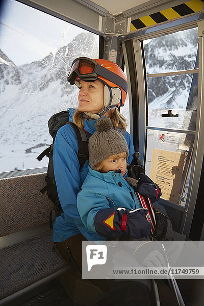 Ältere Skifahrerin und Kleinkindersohn im Skilift sitzend  Neustift  Stubaital  Tirol  Österreich