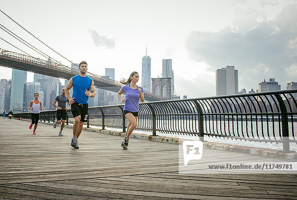 Gruppe von Menschen rennt vor der Brooklyn-Brücke  New York  USA