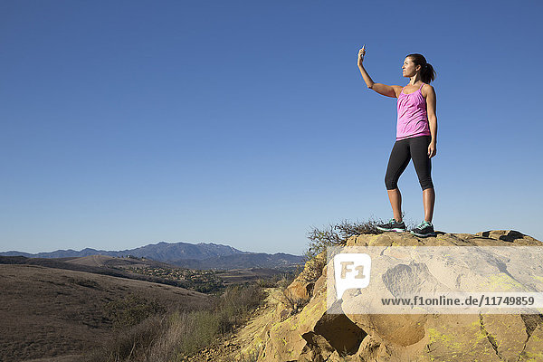 Mature female runner on hill taking smartphone selfie  Thousand Oaks  California  USA