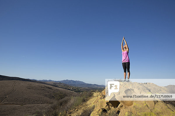 Woman practicing yoga pose on top of hill  Thousand Oaks  California  USA