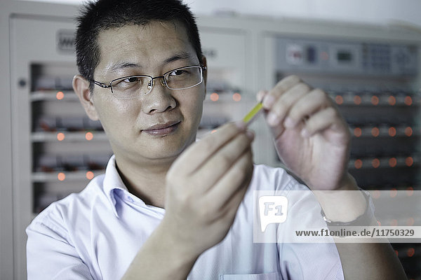 Worker looking at product in ecigarette factory
