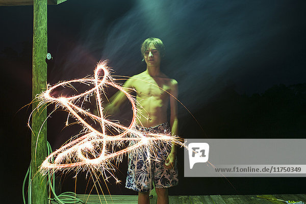 Junge mit Wunderkerze in der Nacht am Unabhängigkeitstag  Destin  Florida  USA