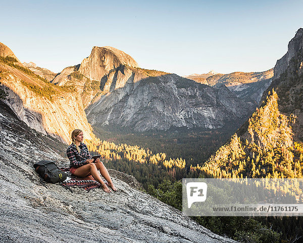 Frau auf Felsen mit Blick auf den Talwald  Yosemite National Park  Kalifornien  USA