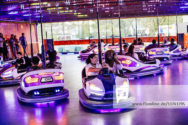 Group of friends at funfair  driving bumper cars