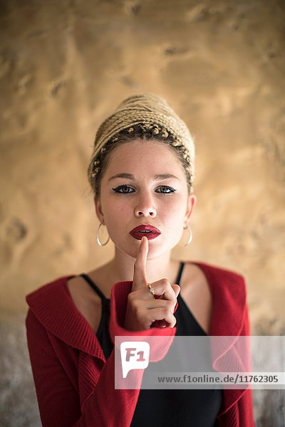 Bildnis einer jungen Frau mit Dreadlocks  Finger an Mund