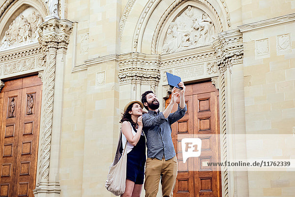 Couple taking digital tablet selfie by Arezzo Cathedral  Arezzo  Tuscany  Italy