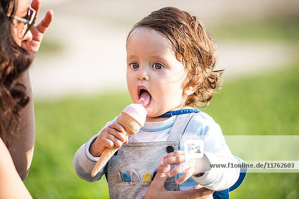 Frau mit Kleinkind-Sohn isst Eistüten im Park