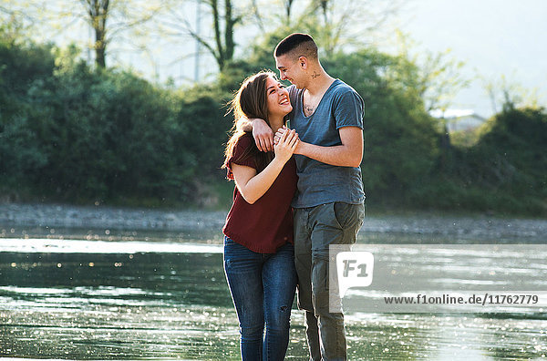 Romantisches Paar steht am Fluss  von Angesicht zu Angesicht  lächelnd