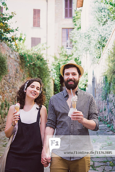 Porträt eines Ehepaares mit Eiswaffeln auf einer gepflasterten Straße  Arezzo  Toskana  Italien