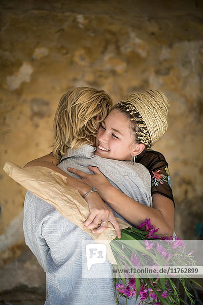 Romantisches junges Paar mit sich umarmendem Blumenstrauss  Mallorca  Spanien