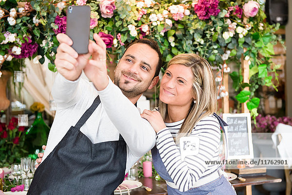 Zwei Floristen im Blumengeschäft  Selbstbedienung  mit Smartphone