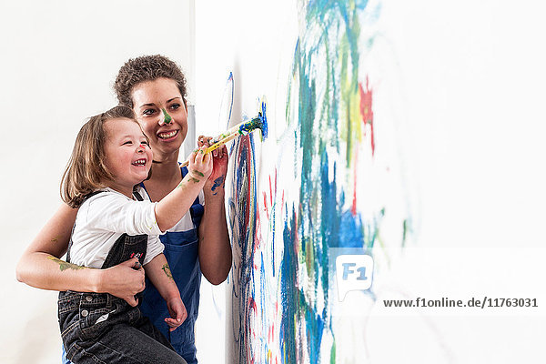 Mutter und Tochter zeichnen auf weisse Wand