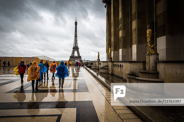 Auf dem Weg zum Eiffelturm trotzen Touristen in bunten Ponchos dem Regen am Palais De Chaillot  Paris  Frankreich  Europa