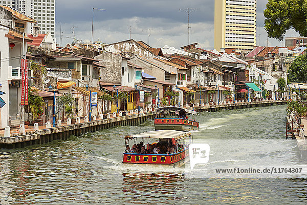 Pleasure boats pass by Chinatown on the Malacca River  Malacca  Malaysia  Southeast Asia  Asia