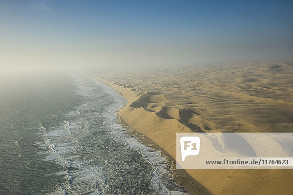 Luftaufnahmen von Sanddünen in der Namib-Wüste  die auf den Atlantischen Ozean treffen  Namibia  Afrika