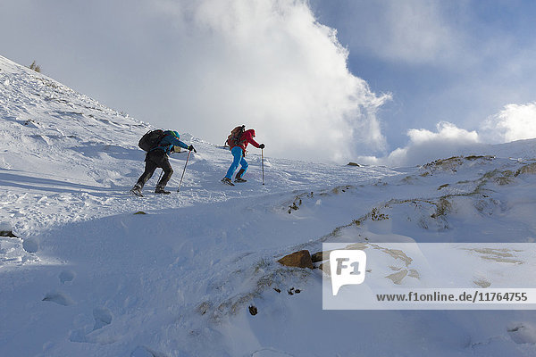Wanderer gehen im verschneiten Tal der Alpe Fora  Malenco-Tal  Provinz Sondrio  Valtellina  Lombardei  Italien  Europa
