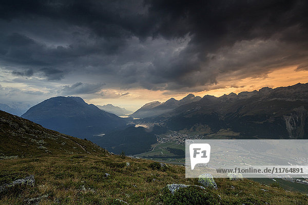 Dunkle Wolken und Sonnenuntergangslicht umrahmen die felsigen Gipfel von Muottas Muragl  St. Moritz  Kanton Graubünden  Engadin  Schweiz  Europa