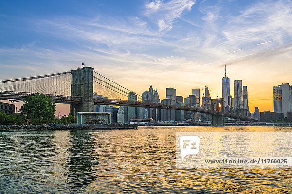 Brooklyn Bridge und Skyline von Manhattan in der Abenddämmerung  vom East River aus gesehen  New York City  Vereinigte Staaten von Amerika  Nordamerika