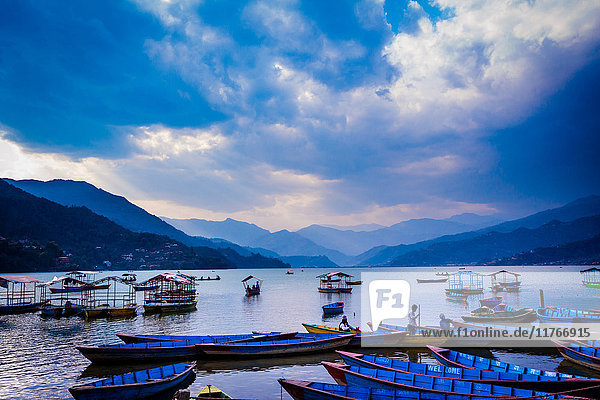 An einem See angedockte Boote bei Sonnenuntergang in Pokhara  Nepal  Asien