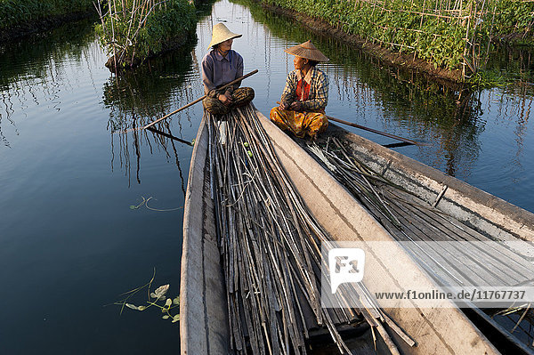 Women take a break while working in the floating gardens on Inle Lake Shan State Myanmar (Burma) Asia