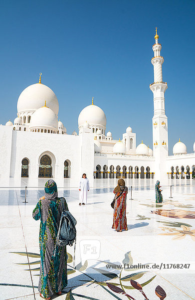Touristen  die gemäß den religiösen Vorschriften vollständig bedeckt sind  fotografieren das Innere der Sheikh Zayed Grand Mosque  Abu Dhabi  Vereinigte Arabische Emirate  Naher Osten