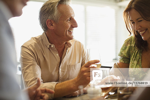 Smiling mature couple drinking wine,  dining at restaurant table