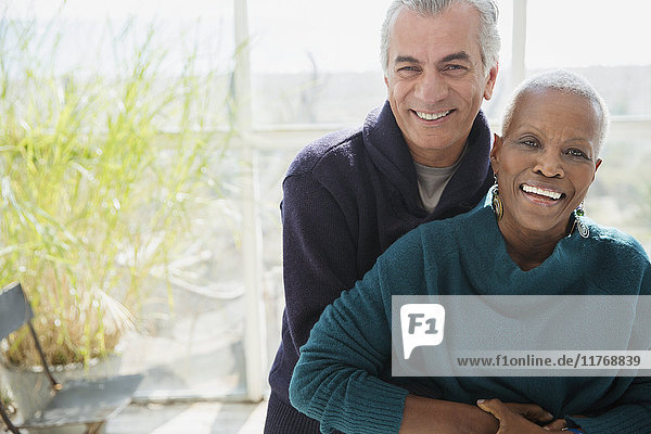 Portrait lächelndes Seniorenpaar auf der Sonnenterrasse