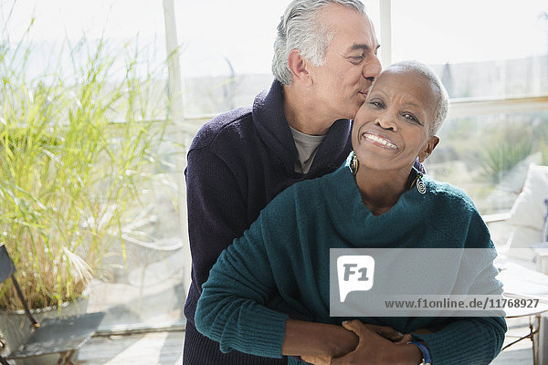 Portrait liebevolles Seniorenpaar umarmend und küssend