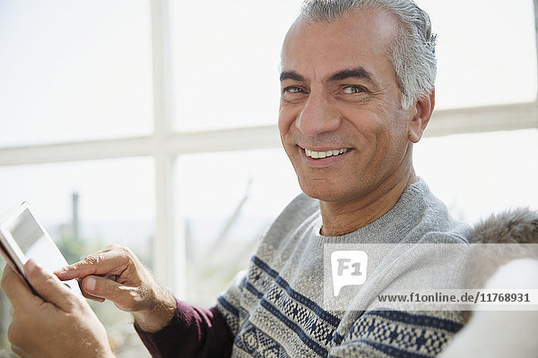 Portrait smiling senior man using digital tablet