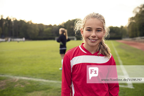 Porträt eines fröhlichen Fußballmädchens auf dem Spielfeld