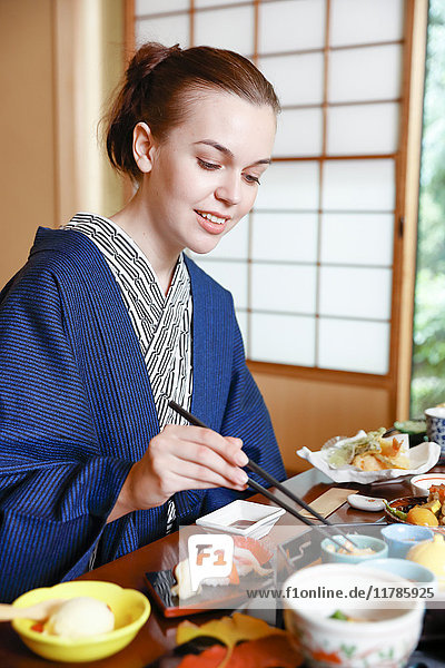 Caucasian woman wearing yukata eating at traditional ryokan  Tokyo  Japan