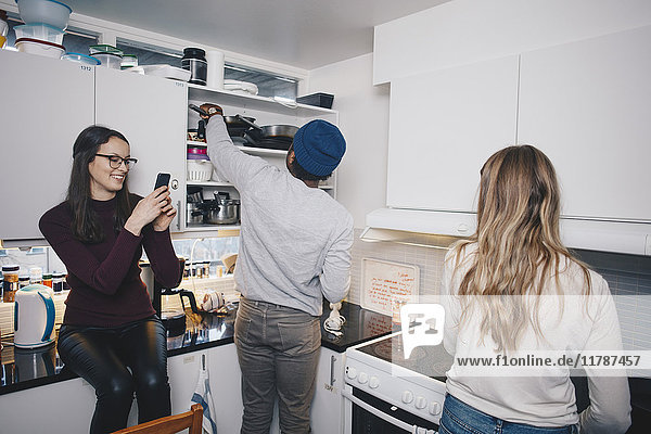 Friends enjoying in kitchen at college dorm