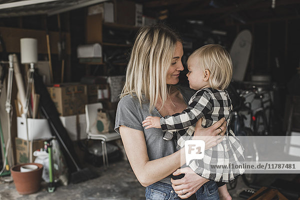 Liebevolle erwachsene Mutter mit Tochter im Lagerraum