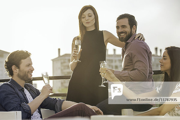 Freunde trinken gemeinsam Champagner im Freien.