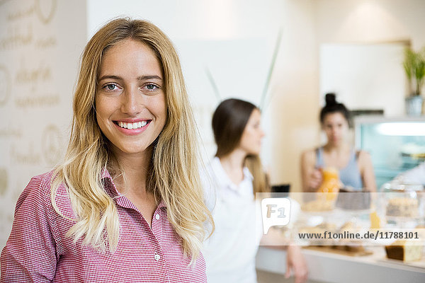 Young woman smiling cheerfully in small business  portrait