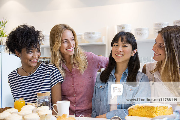 Junge Frauen lächeln zusammen im Cafe