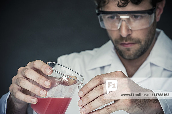 Wissenschaftler gießt Flüssigkeit in das Reagenzglas im Labor